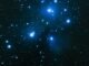 Capture of the Pleiades star cluster, showcasing its luminous blue stars in a vast night sky.